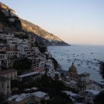Positano at sunset with warm lights over the coast, the perfect setting for dinner
