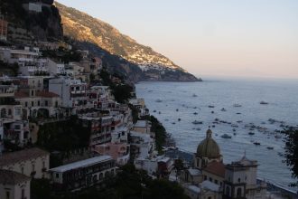 Positano at sunset with warm lights over the coast, the perfect setting for dinner