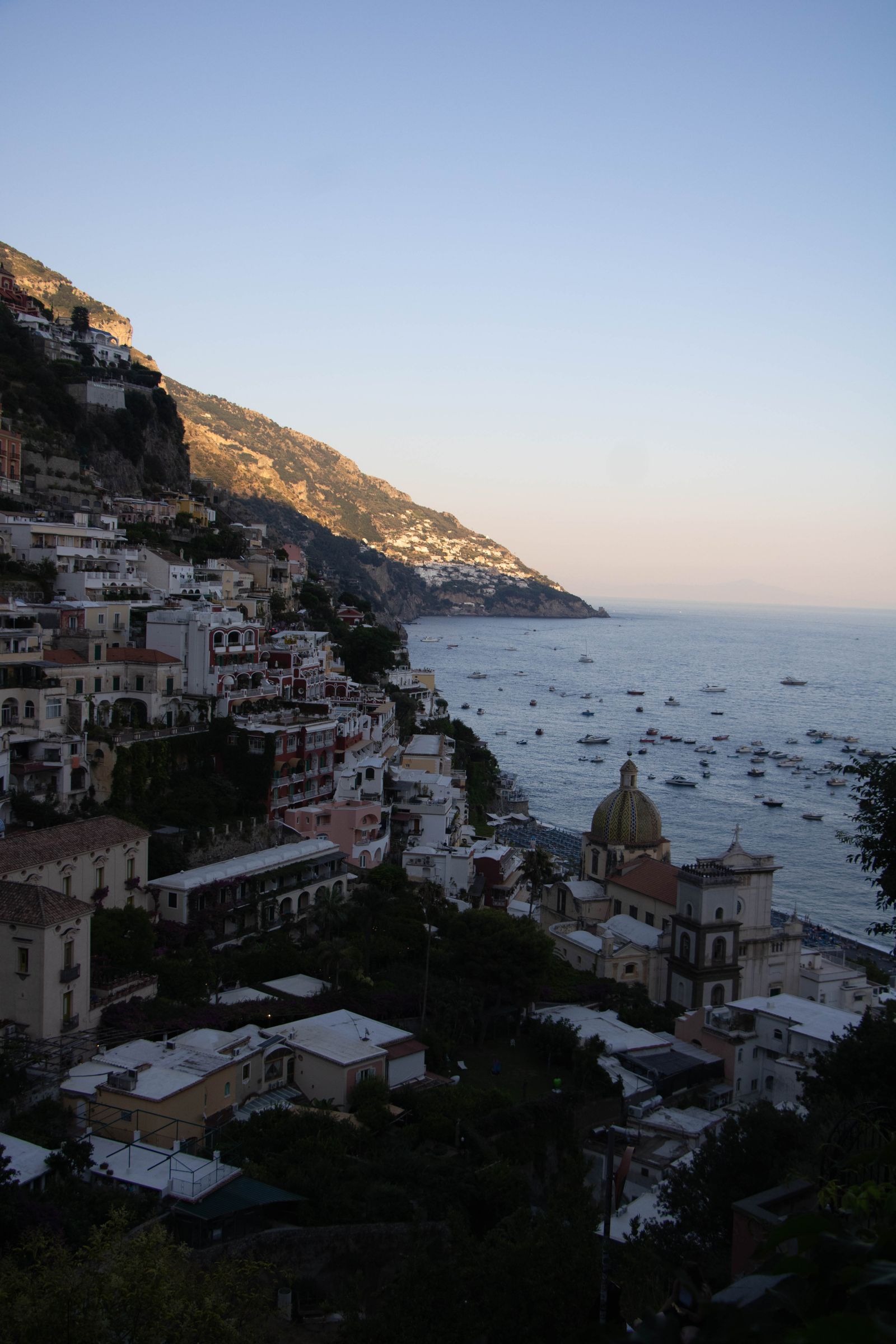 Positano at sunset with warm lights over the coast, the perfect setting for dinner
